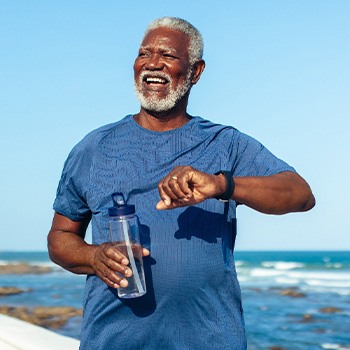Senior man smiling while walking on beach path