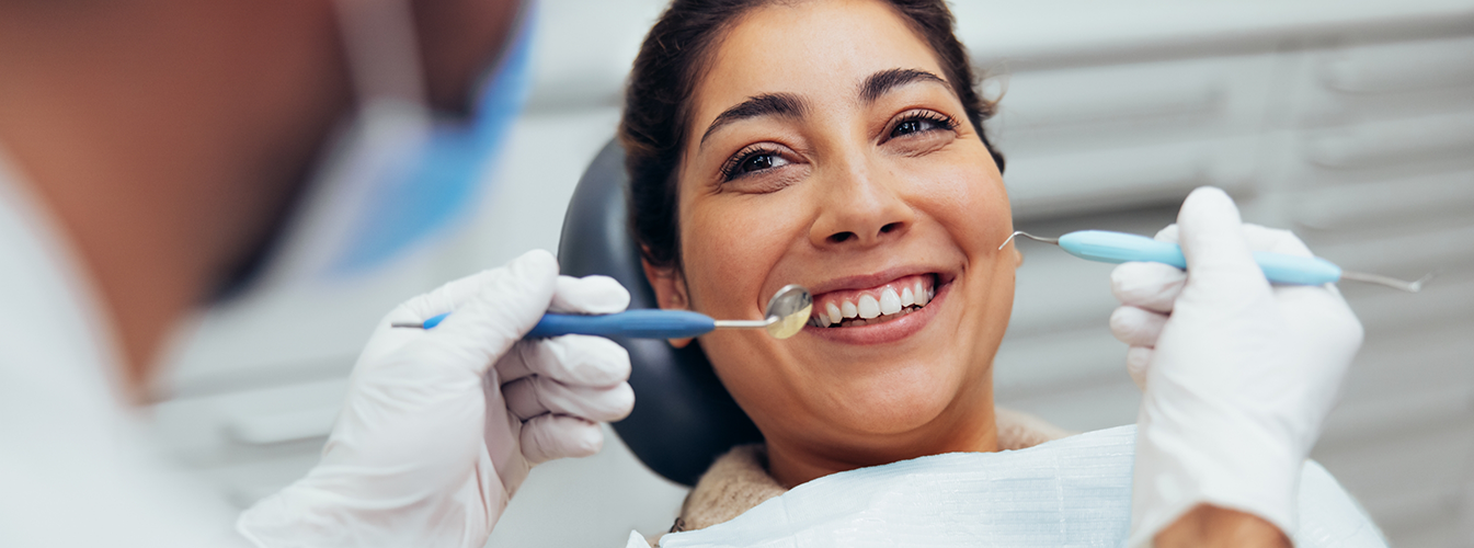Woman in dental chair smiling at dentist in Coppell