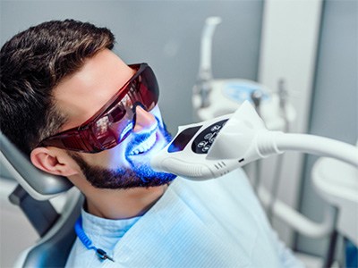 Man undergoing in-office teeth whitening procedure