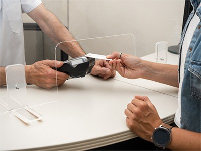 Hands at a counter paying for services