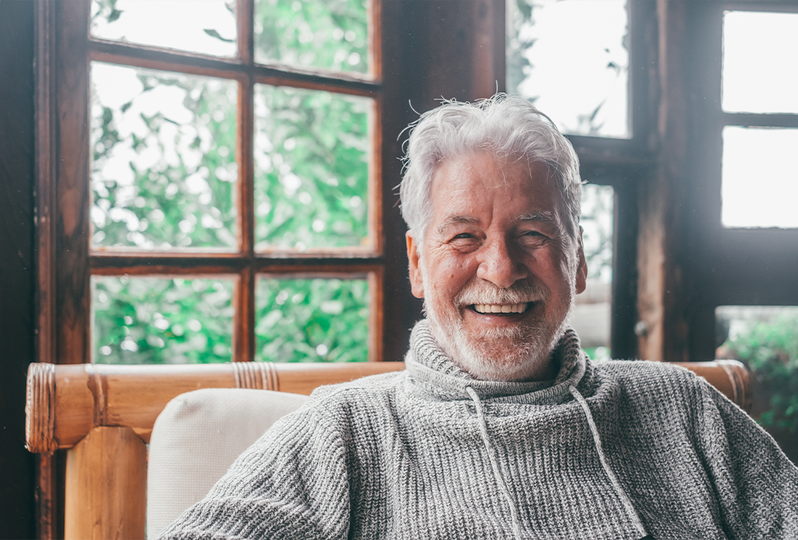 Senior man with grey sweater sitting in cabin