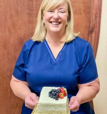 Dr Kiesel holding a small cake