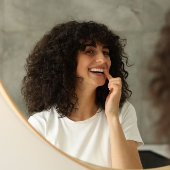 Woman checking her teeth in the mirror