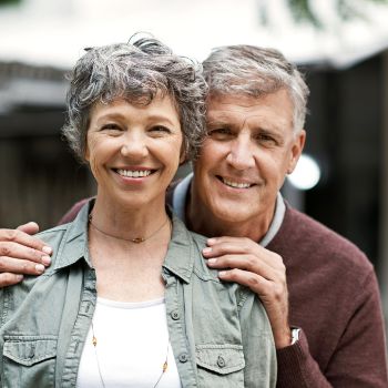 Older man and woman standing and smiling together