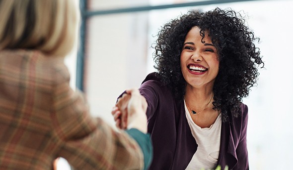 Older woman looking at new smile in the mirror