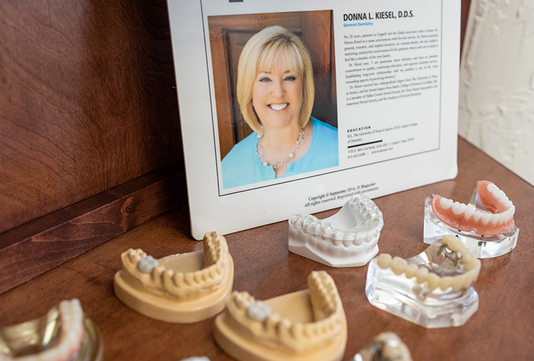 Models of teeth in front of picture of Dr Kiesel