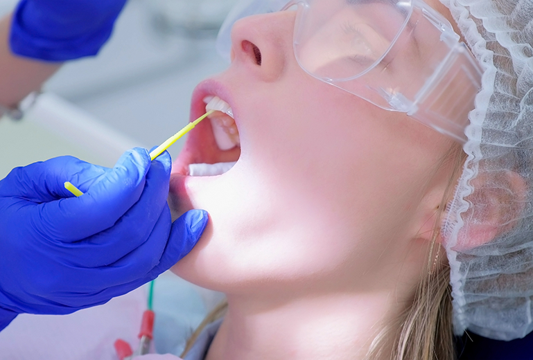 Dental patient having fluoride applied to teeth