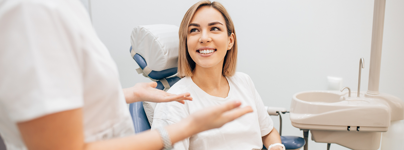 Woman sitting in dental chair and smiling