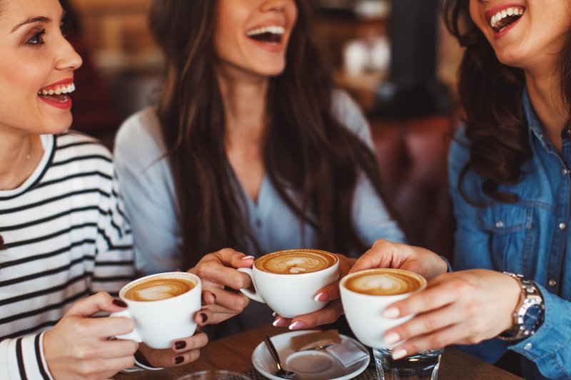 Patient with good dental health drinking coffee with friends